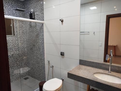 a bathroom with a shower and a toilet and a sink at Sitio Cantin in Piumhi