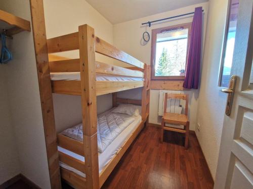 une chambre avec deux lits superposés et une fenêtre dans l'établissement Appartement cosy 6 pers, 2 chambres, à 30m télécabine, proche commerces, balcon et casier à skis - FR-1-265-329, à Modane
