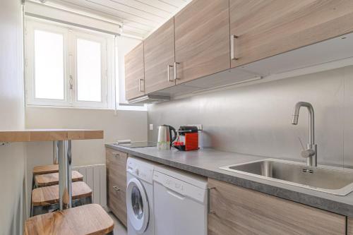 une cuisine avec un évier et une machine à laver dans l'établissement Appartement moderne avec 2 chambres, cœur de Lyon, à Lyon