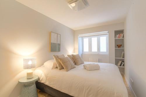 une chambre avec un grand lit blanc avec une fenêtre dans l'établissement Appartement moderne avec 2 chambres, cœur de Lyon, à Lyon