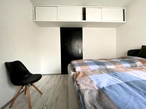 a bedroom with a bed and a chair in it at RumbleintheJungle in Oestrich-Winkel