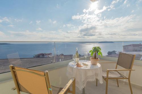 a table and chairs on a balcony with a view of the ocean at Aeli Vista Apartments in Neos Marmaras