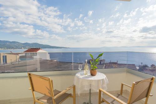 a table and chairs on a balcony with a view of the ocean at Aeli Vista Apartments in Neos Marmaras