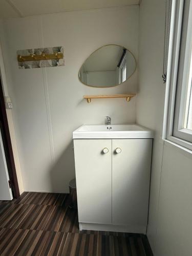 une salle de bain avec un lavabo blanc et un miroir dans l'établissement Mobil home Capbreton, à Capbreton