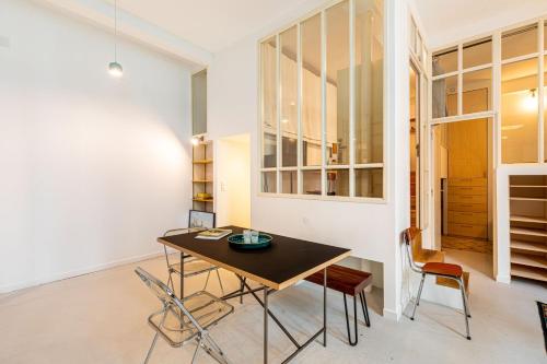 une salle à manger avec une table et des chaises dans l'établissement GuestReady - Midcentury Maisonette in the 10th, à Paris
