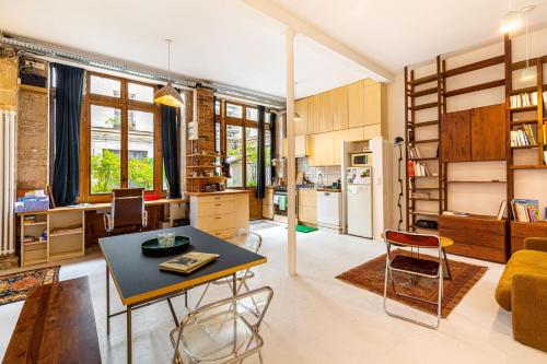 une cuisine et un salon avec une table et des chaises dans l'établissement GuestReady - Midcentury Maisonette in the 10th, à Paris