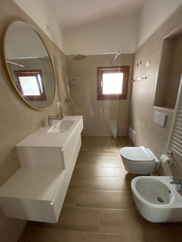 a bathroom with a sink and a toilet and a mirror at Villa Valeria in Solanas