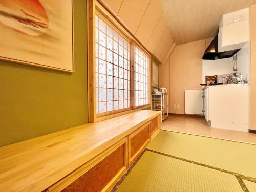 a living room with a large window and a kitchen at 上野日式民宿 in Tokyo