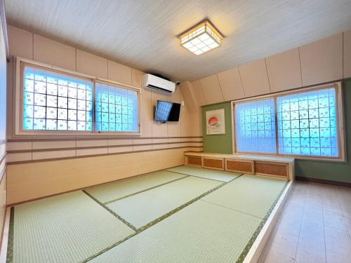 a large empty room with windows and a tv at 上野日式民宿 in Tokyo