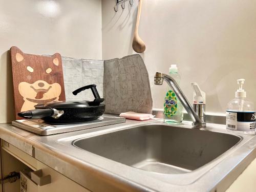a kitchen sink with a pan on a counter at 上野日式民宿 in Tokyo