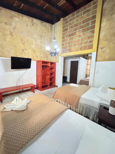 a hotel room with two beds and a tv at La Posadita de Bolonia in Managua