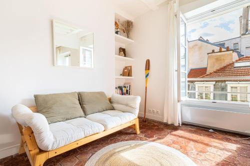 un salon avec un canapé et une fenêtre dans l'établissement GuestReady - Superb haven of peace in Marais, à Paris