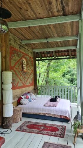 a bed in a wooden room with a cat laying on it at Utopia Climbing Community in Rti
