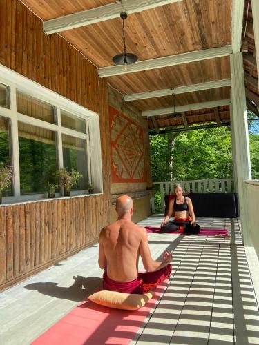 a man and a woman doing yoga on a patio at Utopia Climbing Community in Rti
