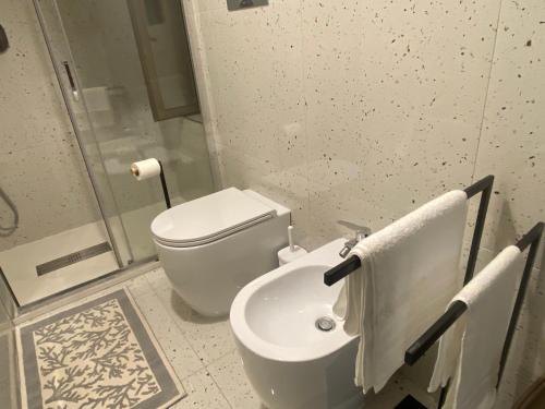 a white bathroom with a toilet and a sink at Casa Alleria in Battipaglia