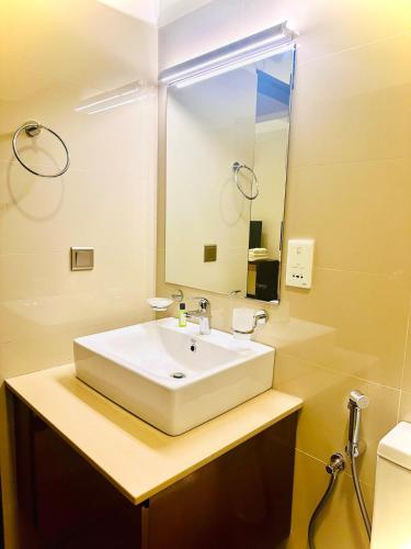 a bathroom with a white sink and a mirror at Coastal Comfort by Ocean Breeze in Negombo