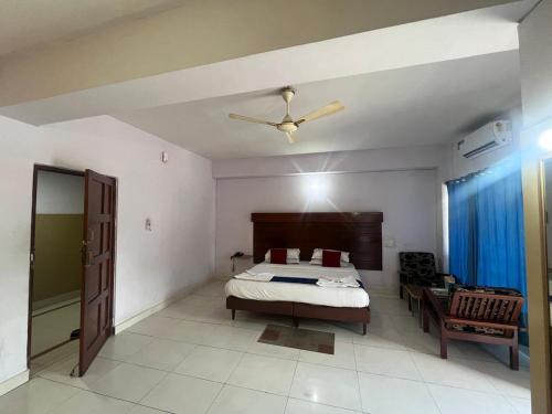 a bedroom with a bed and a ceiling fan at Hotel sai arcade in Bengaluru
