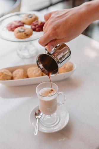 a person pouring coffee into a cup on a table at Puerto Dijama Hotel Boutique in Carmelo