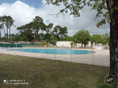 une piscine entourée d'une clôture dans l'établissement Le gazon de ronce, à La Tremblade