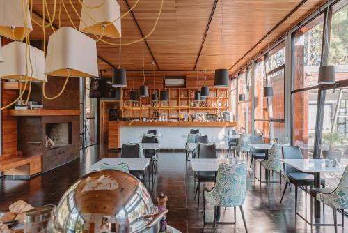 a restaurant with tables and chairs and windows at Puerto Dijama Hotel Boutique in Carmelo