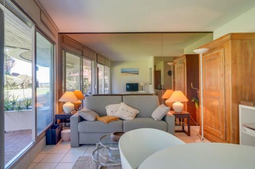 un salon avec un canapé et une fenêtre dans l'établissement Studio Cabine avec Terrasse, Accès Plage Pereire – Boulevard de l'Océan, Arcachon, à Arcachon