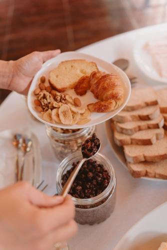 a person holding a plate of food on a table at Puerto Dijama Hotel Boutique in Carmelo
