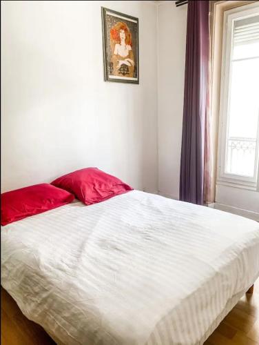 - un lit blanc avec des oreillers rouges dans une chambre dans l'établissement Nice view in La Défense, à Puteaux