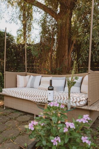 a white couch with a bottle of wine on a patio at Puerto Dijama Hotel Boutique in Carmelo