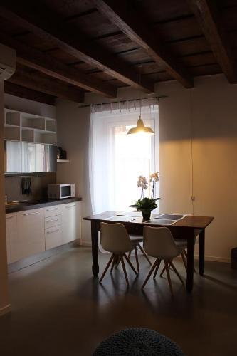 cocina con mesa, sillas y ventana en Residenza Navi, en Verona