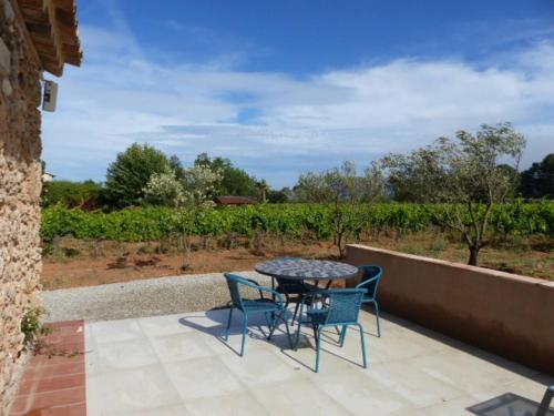 a patio with a table and chairs in front of a vineyard at Studio Vu sur l'O2 Là in La Motte