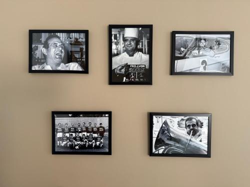 a wall with four framed pictures on a wall at Chambre Univers Bocuse - à 200 m de la Légende in Collonges-au-Mont-dʼOr