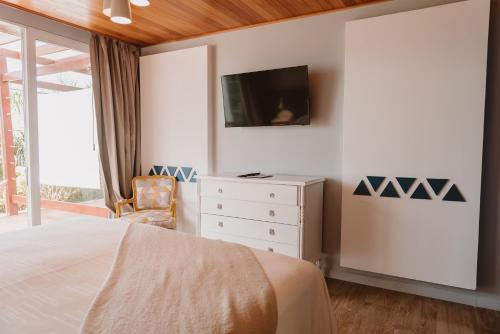 a bedroom with a bed and a tv on a wall at Puerto Dijama Hotel Boutique in Carmelo