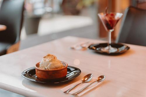 a table with a bowl of ice cream and a drink at Puerto Dijama Hotel Boutique in Carmelo