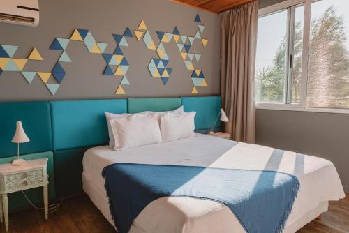 a bedroom with a bed with a blue headboard at Puerto Dijama Hotel Boutique in Carmelo