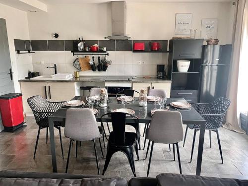 una cucina con tavolo da pranzo e sedie di LES GITES CHEROIS sweet home maison 8 personnes a Les Chères