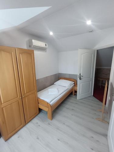 a small room with a bed and a door at Euro Panzio in Debrecen