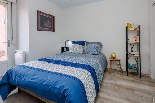 une chambre avec un lit avec une couette bleue dans l'établissement Le Maréchal - Parking - Terrasse - Albi, à Albi