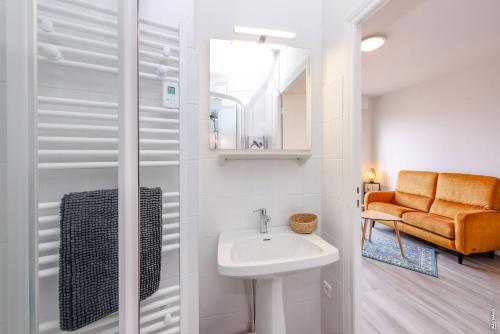 La salle de bains est pourvue d'un lavabo et d'une chaise orange. dans l'établissement Le Maréchal - Parking - Terrasse - Albi, à Albi
