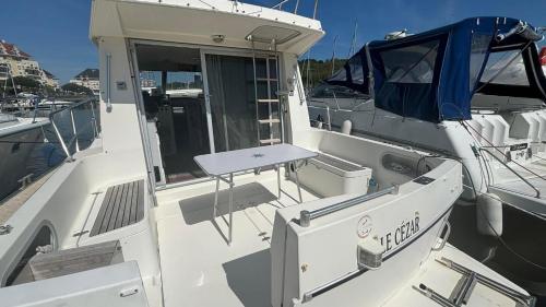 a white boat is docked in the water at Bateau Le Cezar in Dives-sur-Mer