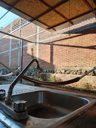 a sink in a kitchen with a brick wall at Iguana Coliving in Oaxaca City