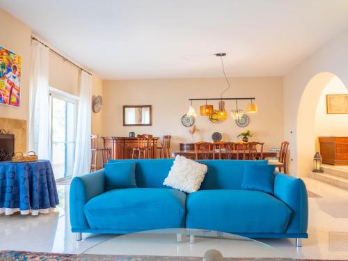 a blue couch in a living room with a table at Villa Palma - Sunset Sea Views with Pool, Jacuzzi, Sauna and Games Room in Mellieħa