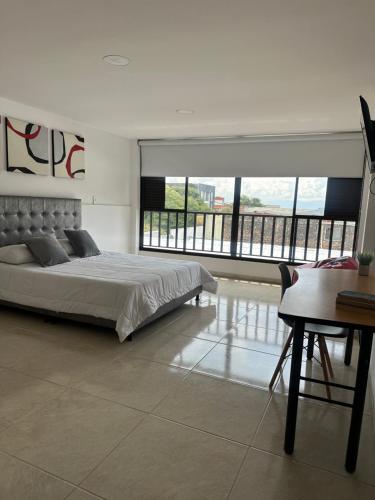 ein Schlafzimmer mit einem Bett, einem Tisch und einem Schreibtisch in der Unterkunft El refugio in Pereira