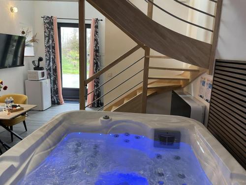 une baignoire jacuzzi dans un salon avec un escalier dans l'établissement Le domaine de kermel, à Pleubian