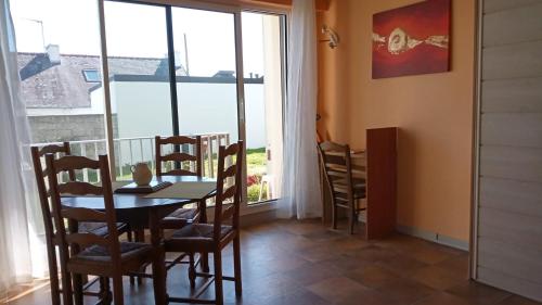 une salle à manger avec une table et des chaises et une fenêtre dans l'établissement Studio à 100 m de la plage, à Audierne