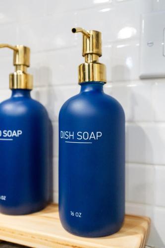 two blue soap bottles sitting on a wooden shelf at Elevated Stay 3BR in Addison in Addison