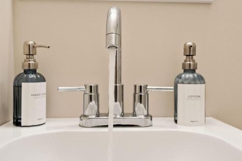 two bottles of soap are sitting on a bathroom sink at Elevated Stay 3BR in Addison in Addison