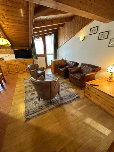 a living room with leather furniture and a table at Effealatapartments - La Perla della Val di Sole in Dimaro