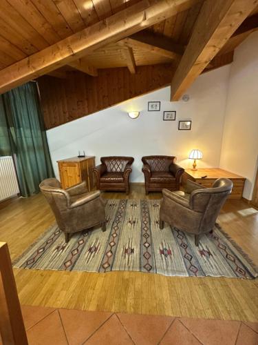 a living room with chairs and a table and a rug at Effealatapartments - La Perla della Val di Sole in Dimaro