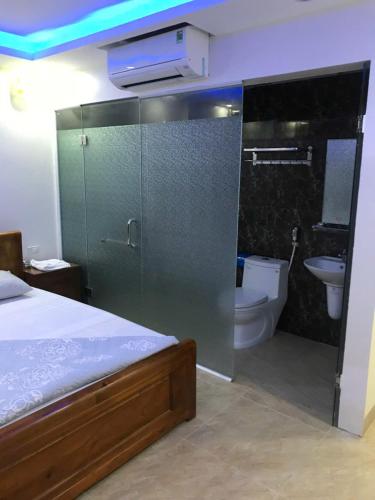 a bedroom with a bed and a bathroom with a toilet at Bich Phuong Hotel 3 in Ha Giang