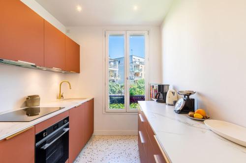 une cuisine avec des armoires orange et une fenêtre dans l'établissement GuestReady- Eclectic Delights in Saint-Ouen, à Saint-Ouen